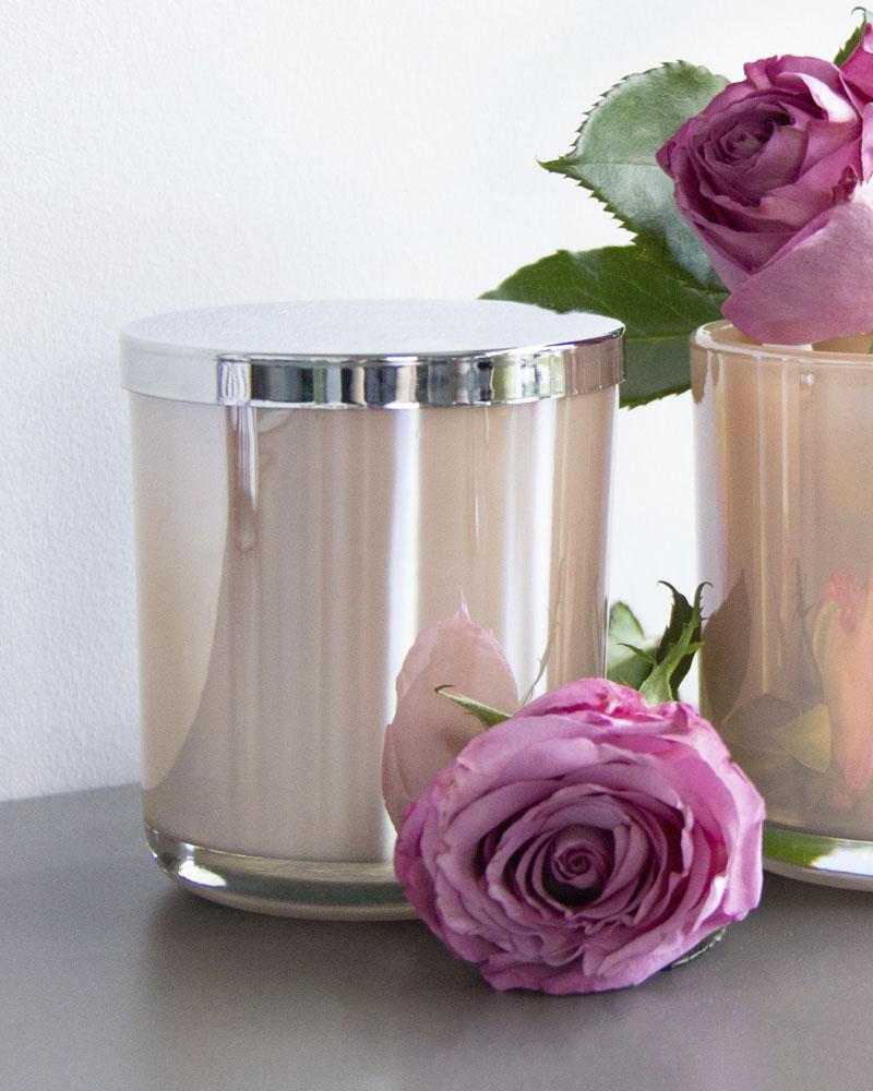 two cylindrical pink pots with a silver lid and decorative roses